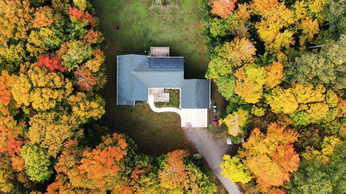 Looking straight down on a single house surrounded by autumn trees